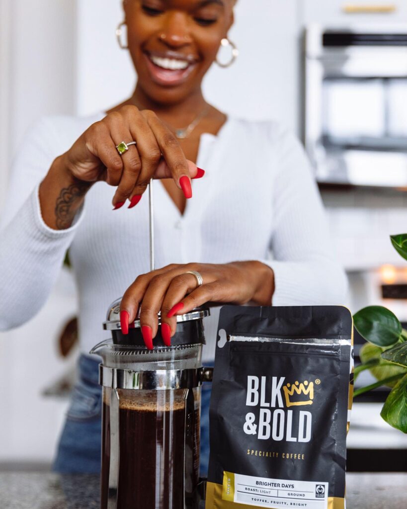 A black woman making Blk and Bold coffee in a french press