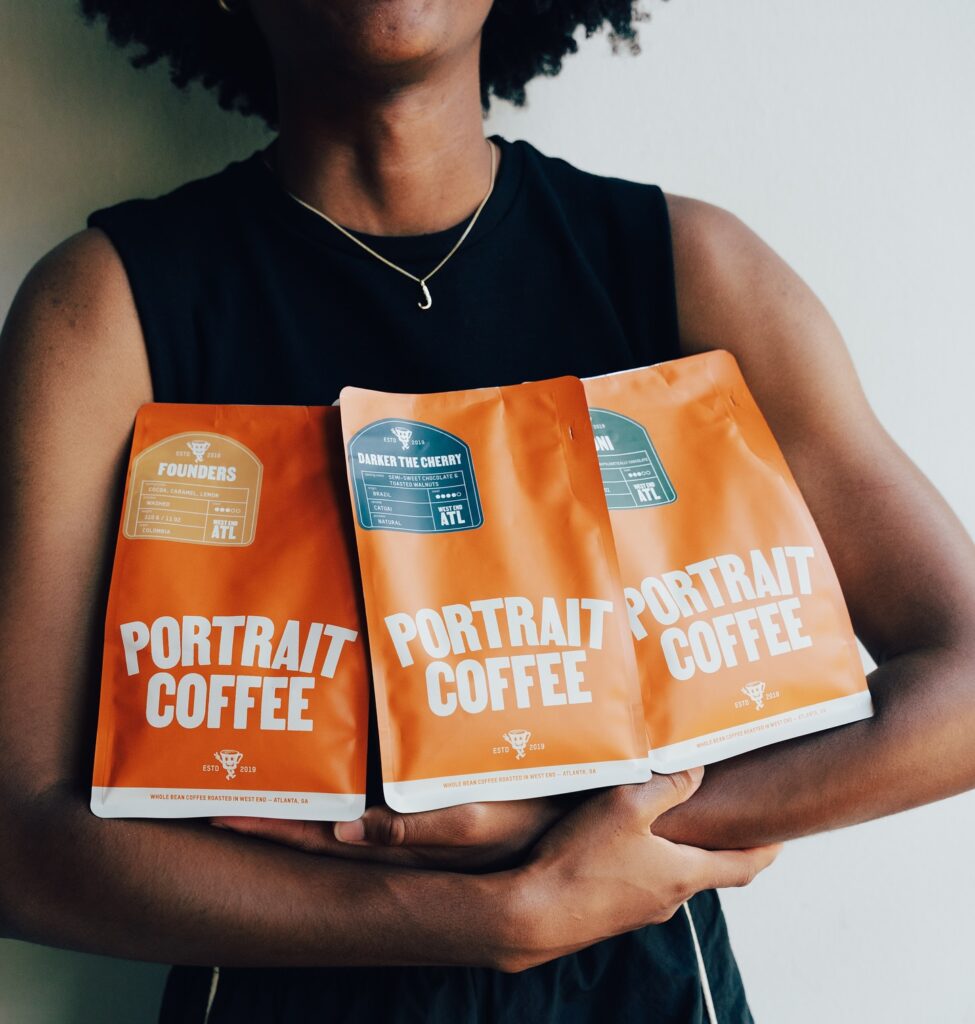 Woman holding three varieties of Portrait Coffee