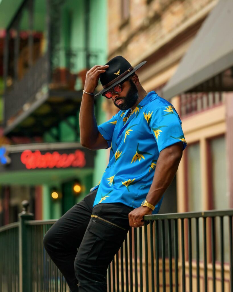 A Black Man wearing a black fedora and blue short sleeved shirt from Southern Gents