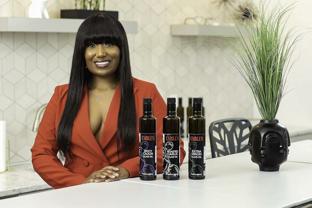 Emblem oil's owner stand showcasing her three varieties of Olive Oil