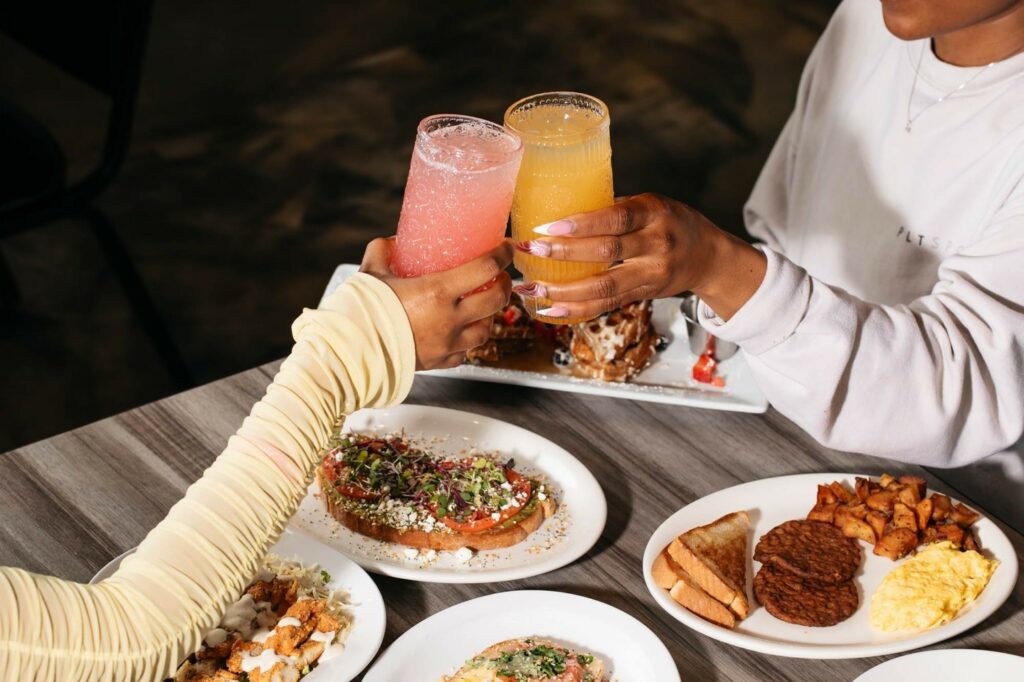 Two women cheers glasses over Brunch at Soiree Coffee